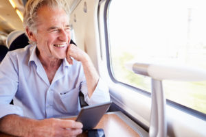 older man looking out train window