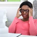 Woman holding her head with an uncomfortable look on her face